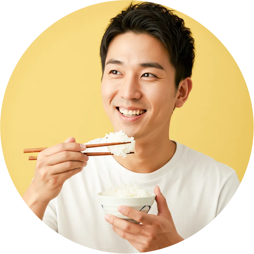 イメージ：ご飯茶碗に盛られた白米をお箸で口に運んでいる男性