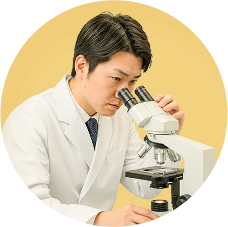 顕微鏡を見ている研究員の写真